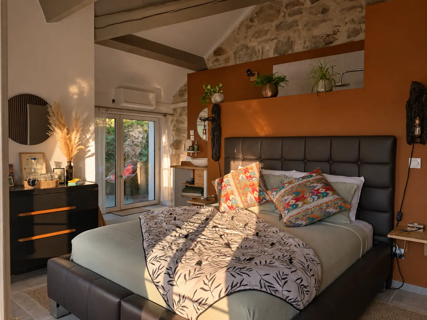 Le lit et les murs de pierre de la suite MAPU